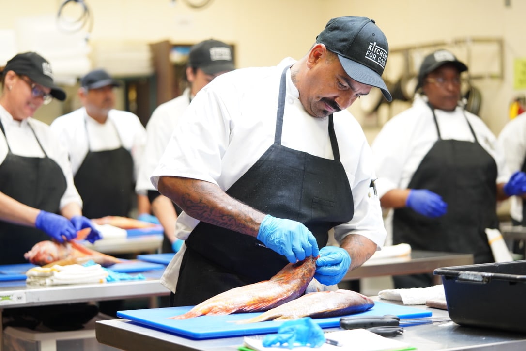 Apprentice with fish learning on the culinary apprenticeship