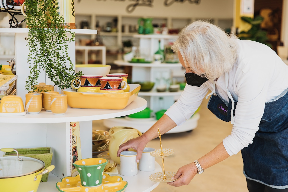 Volunteer at Kitchens for Good Shop organizing products on shelf